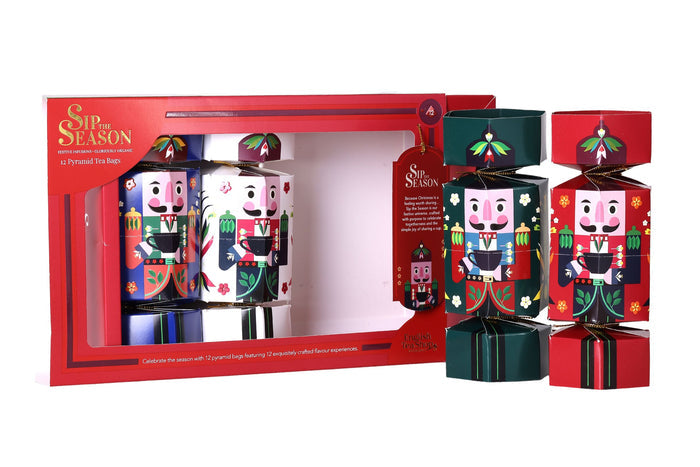 Two green and red nutcracker Christmas cracker tea boxes displayed standing upright next to the opened English Tea Shop gift set.